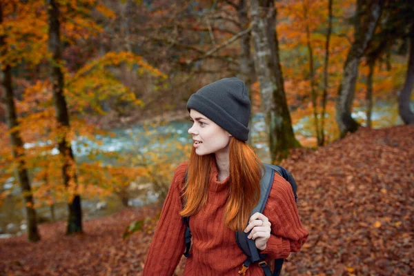 Kobieta turysta spacery w lesie jesienią w przyrodzie w pobliżu rzeki i pozostawia krajobraz — Zdjęcie stockowe
