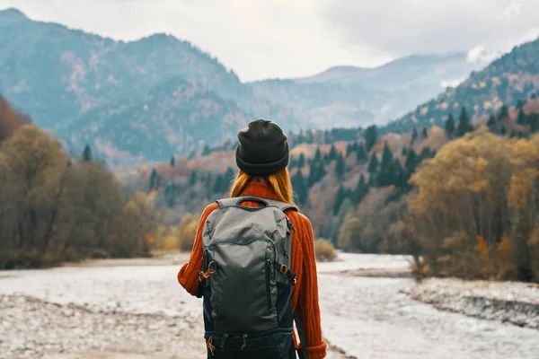 Mujer excursionista con una mochila de descanso en las montañas en la naturaleza cerca del río —  Fotos de Stock