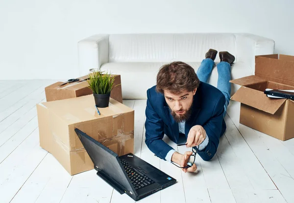 Un homme se trouve devant un ordinateur portable boîtes avec des choses déballer Office homme d'affaires professionnel — Photo