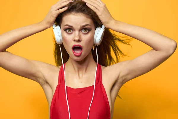 Mujer emocional con auriculares escuchar música fondo amarillo de cerca —  Fotos de Stock