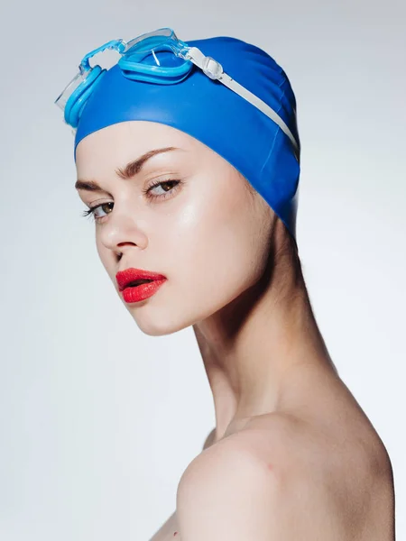 Vista lateral de uma mulher bonita em um chapéu de natação azul, ombros nus — Fotografia de Stock