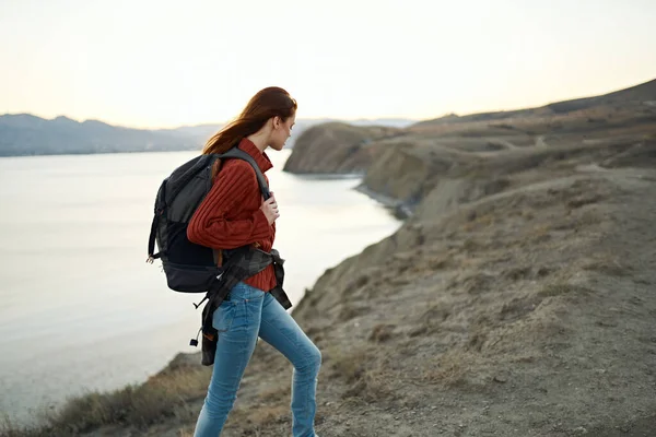 Donna sale sulle montagne e guarda il mare in lontananza paesaggio nuvole viaggi turismo — Foto Stock