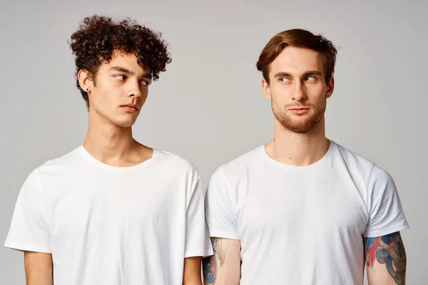 하얀 티셔츠를 입은 두 남자가 우정의 감정 옆에 서 있습니다 — 스톡 사진