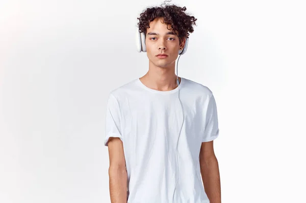 Camiseta adolescente y en auriculares sobre un fondo claro modelo de nueva tecnología — Foto de Stock