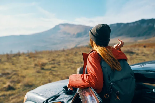 Viajero con una mochila cerca del coche en las montañas en verano y el cielo azul aire fresco — Foto de Stock