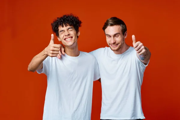 흰색 티셔츠를 입은 두 남자가 손을 흔들며 우정을 나누는 모습 — 스톡 사진