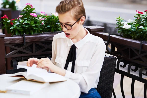 Femme en chemise cravate à la table dans le café lunettes sur le visage éducation science livre ouvert — Photo