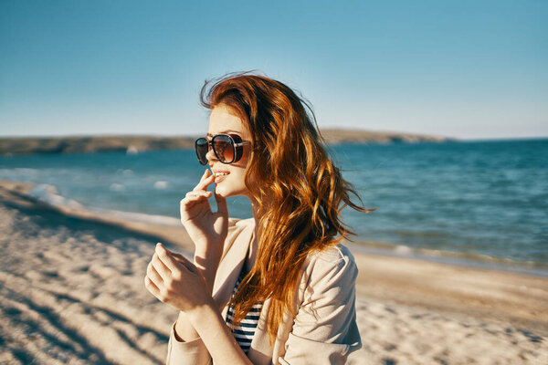 woman with glasses red hair model beige sweater smile sea beach