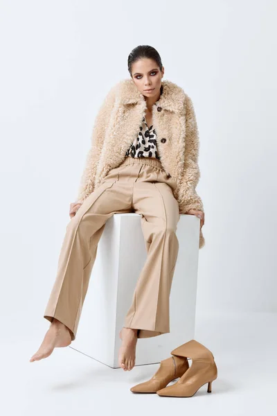 Attraktiv fashionabla kvinna bär beige kläder barfota poserar sittande — Stockfoto