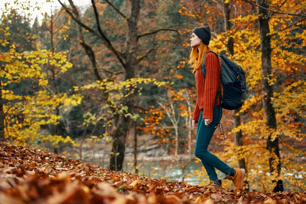 Žena v podzimním lese v blízkosti řeky krajina žluté listy turistika — Stock fotografie