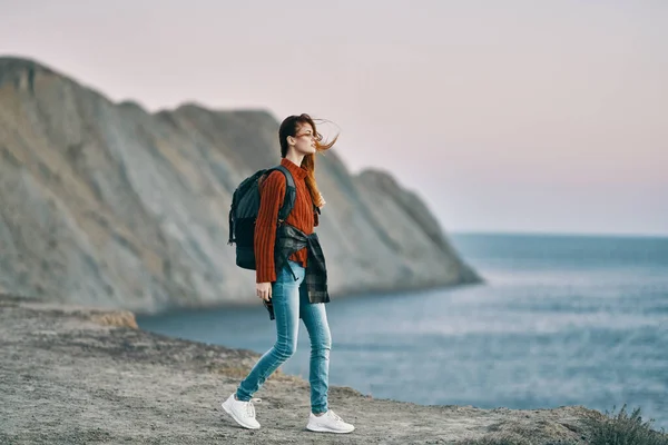 travel woman with backpack sweater mountain sea sunset nature