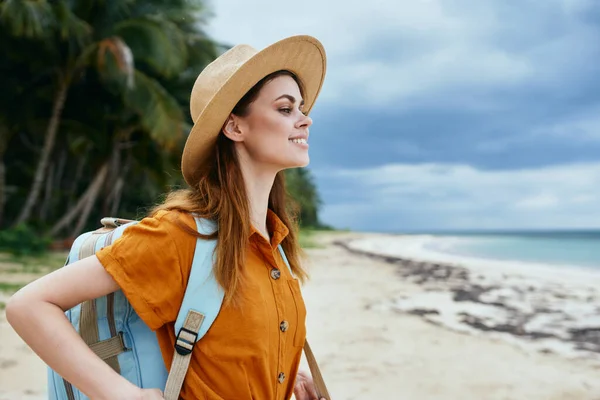 Lycklig kvinna med ryggsäck och i en solklänning på stranden nära havet beskuren utsikt — Stockfoto