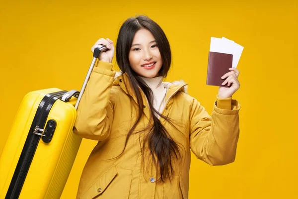 여권 비행기 표를 들고 있는 여성, 여행 가방을 들고 따뜻 한 재킷을 입고 있다. — 스톡 사진