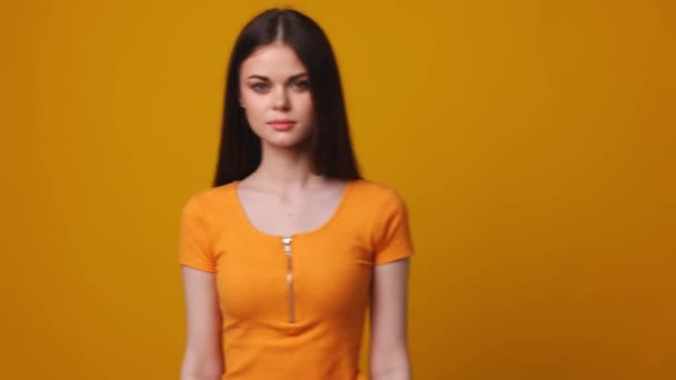 Молода жінка на жовтому фоні, студія — стокове відео
