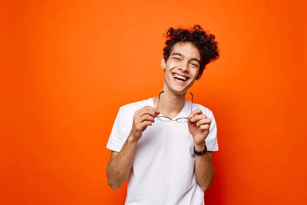 Allegro ragazzo ricci occhiali per capelli moda sfondo arancione — Foto Stock