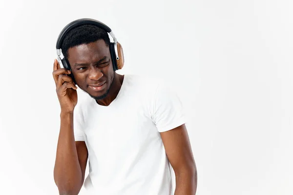 Hombre emocional en auriculares escuchando música luz fondo estilo de vida — Foto de Stock