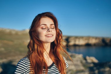 Nehir kıyısındaki sahilde mutlu bir kadın. Yüksek uçurumlar. Temiz hava.