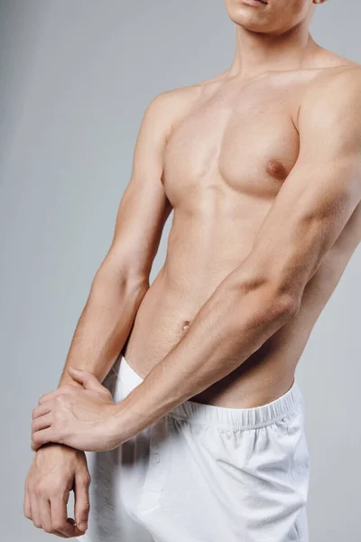 Atleta con figura de torso culturista gris fondo pantalones cortos vista recortada — Foto de Stock