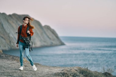 Sırt çantalı gezgin kadın, dağ denizi günbatımı doğa.