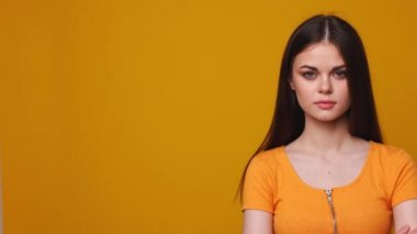 Sarı arka planda genç bir kadın, stüdyo.