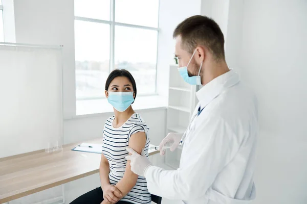 병원의 건강을 보호하기 위해 의료용 마스크로 예방 접종을 하는 여성 — 스톡 사진