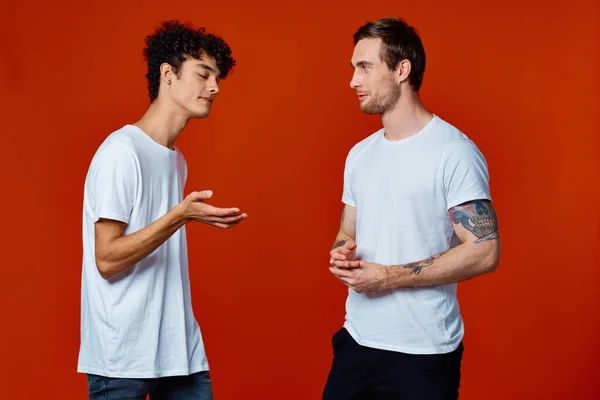Dos amigos alegres en camisetas blancas comunicación aislado fondo divertido — Foto de Stock