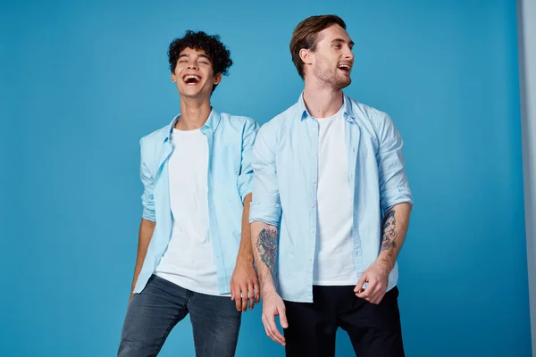 Amici in camicie sbottonate e bianco t-shirt jeans blu sfondo divertente comunicazione partito — Foto Stock