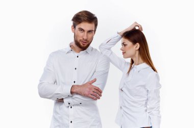 Gömlekli bir iş adamı ve arka planda çalışan bir kadın partnerlerinin elleriyle el kol hareketi yapıyor.