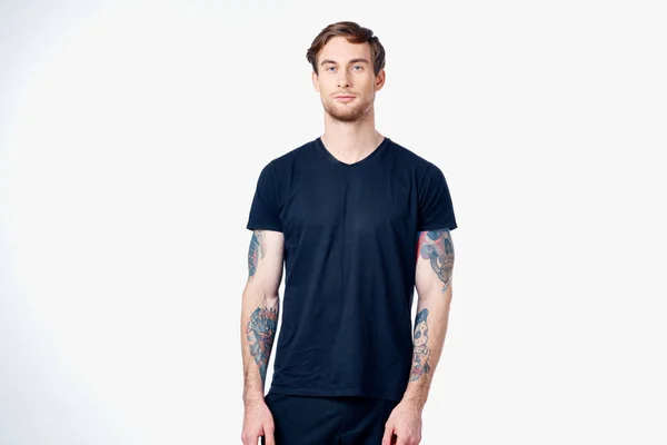 Uomo sportivo in t-shirt blu con tatuaggi sulle braccia su sfondo bianco Copy Space — Foto Stock