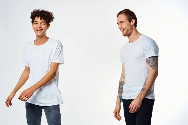 흰색 티셔츠를 입은 두 명의 쾌활 한 친구들은 긍정적 인 긍정적 인 배경에서 즐거움을 느낀다 — 스톡 사진