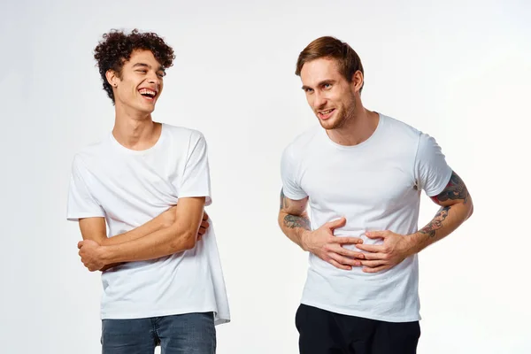 Dos hombres con camisetas blancas están de pie junto a las emociones de amistad — Foto de Stock