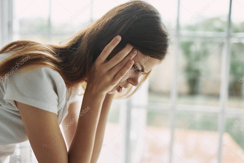 woman at home holding her head loneliness depression