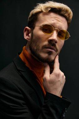 Turuncu kazaklı ve ceketli genç adam el ele tutuşmuş.