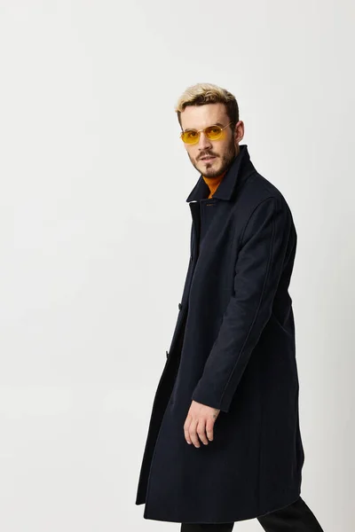 Hombre guapo con gafas amarillas negro abrigo moda atractivo look estudio — Foto de Stock