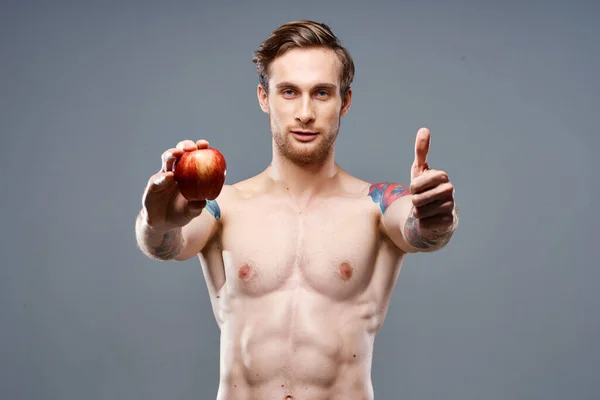 Atlético chico con un torso bombeado estilo de vida saludable nutrición vitaminas manzana roja — Foto de Stock