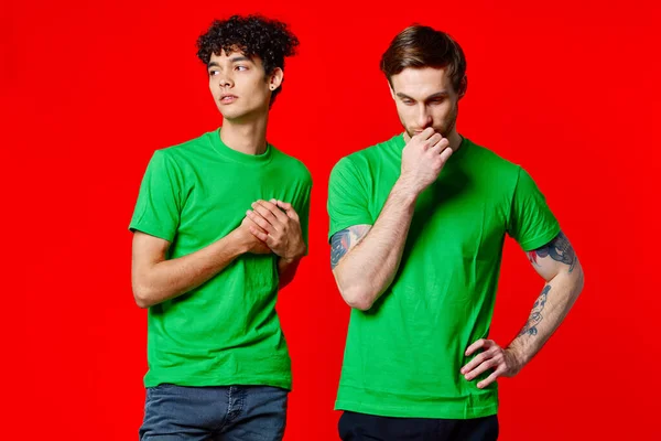 Due amici in verde t-shirt comunicazione stile di vita rosso sfondo — Foto Stock