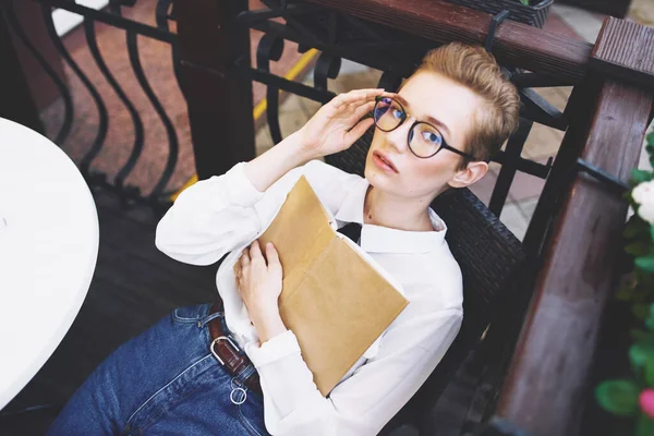 Žena u stolu s knihou v ruce brýle na tváři kavárny interiér ulice léto — Stock fotografie