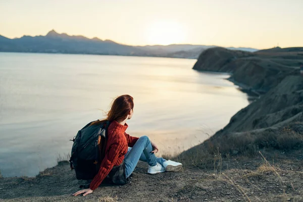 Un viaggiatore con uno zaino sulla sabbia si rilassa nella natura vicino al mare in montagna — Foto Stock
