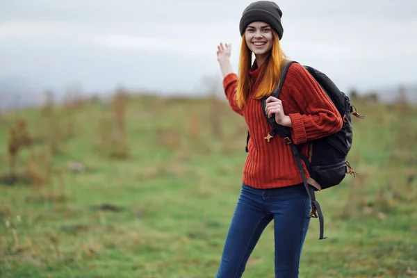 一个快乐的女人穿着秋天的衣服，带着一把小刀在山水里旅行 — 图库照片