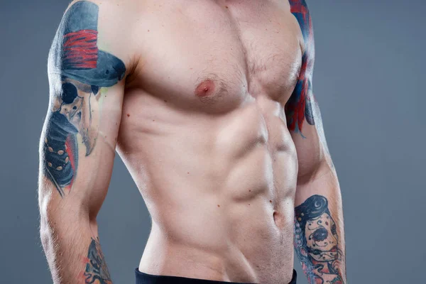 Sexy atleet met naakte romp en opgepompte spieren tattoo grijs achtergrond model — Stockfoto