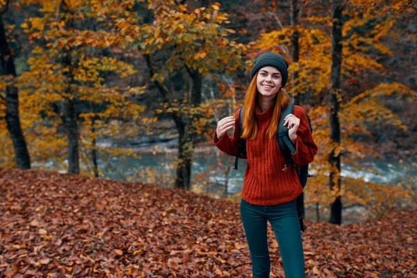 Outono parque caído folhas altas árvores rio no fundo e mulher turismo de viagem — Fotografia de Stock