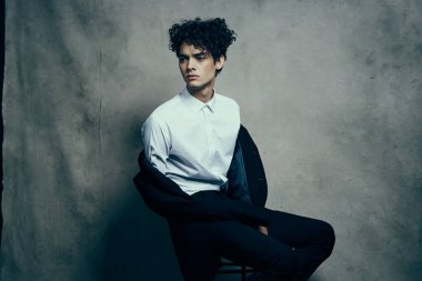 Beyaz gömlekli adam siyah ceketli moda stüdyosu manzaralı.