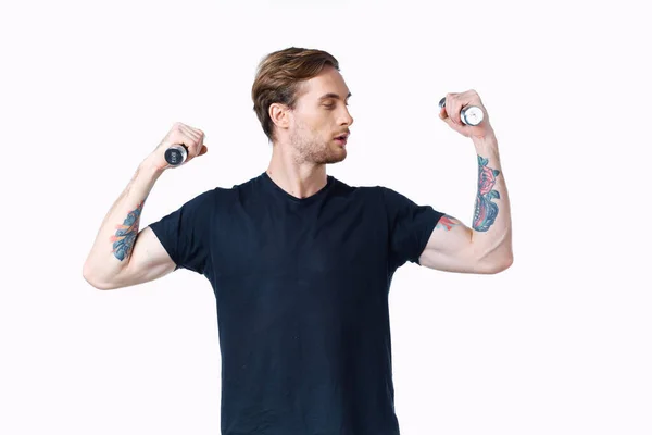 Uomo con pompato fino muscoli di braccia e manubri nero t-shirt sfondo bianco — Foto Stock