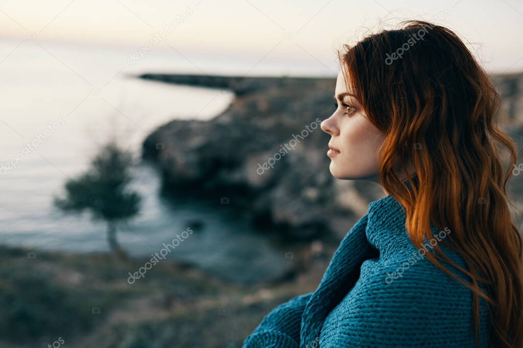 red-haired woman in mountains in nature blue plaid sunset landscape