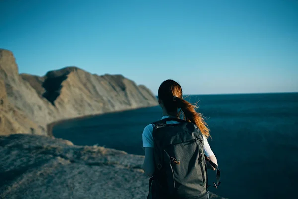Жінка з рюкзаком в горах на природі вид ззаду — стокове фото