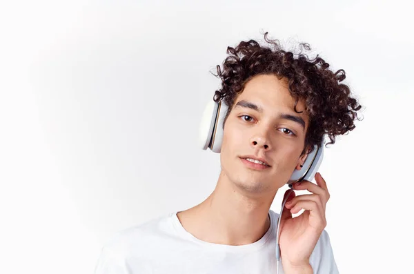 Vrolijke man met krullend haar in hoofdtelefoon luistert naar muziek emoties — Stockfoto