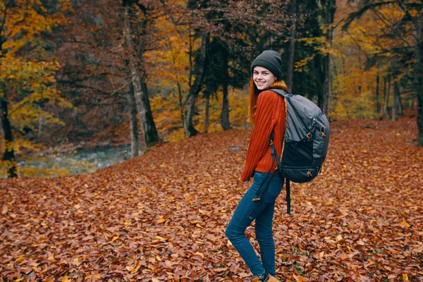 Caminhadas mulher viagem com mochila nas costas e caído folhas secas natureza floresta parque modelo — Fotografia de Stock
