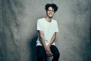 Beyaz tişörtlü, kıvırcık saçlı yakışıklı adam gözlüklü moda.