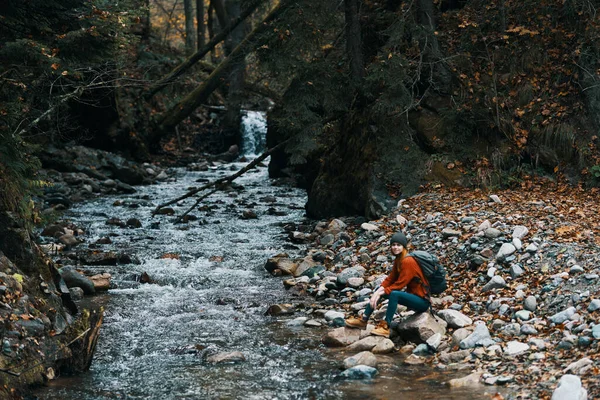 Vrouw reiziger in de buurt van een berg rivier in het bos zit op de kust herfst landschap — Stockfoto