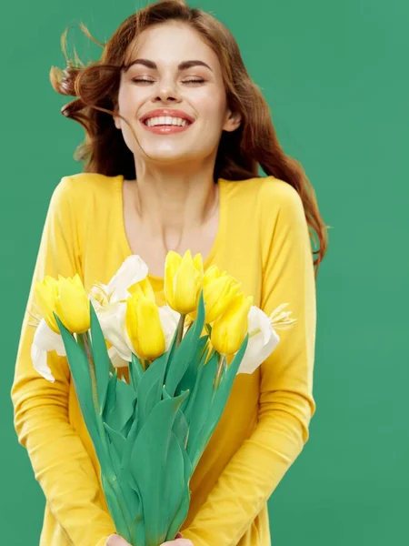 Mulher feliz com buquê de flores amarelas no fundo verde — Fotografia de Stock